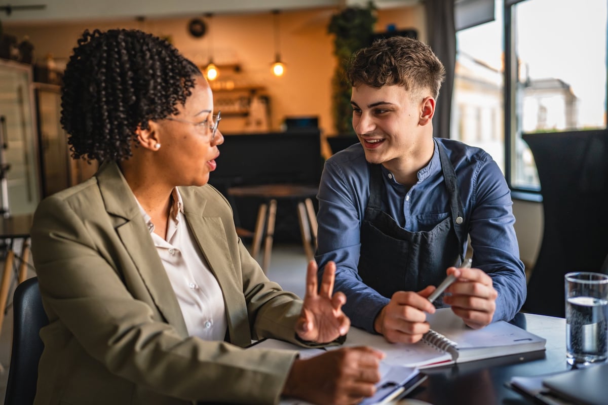 A young entrepreneur in a meeting with a financial advisor reviewing and planning a project together